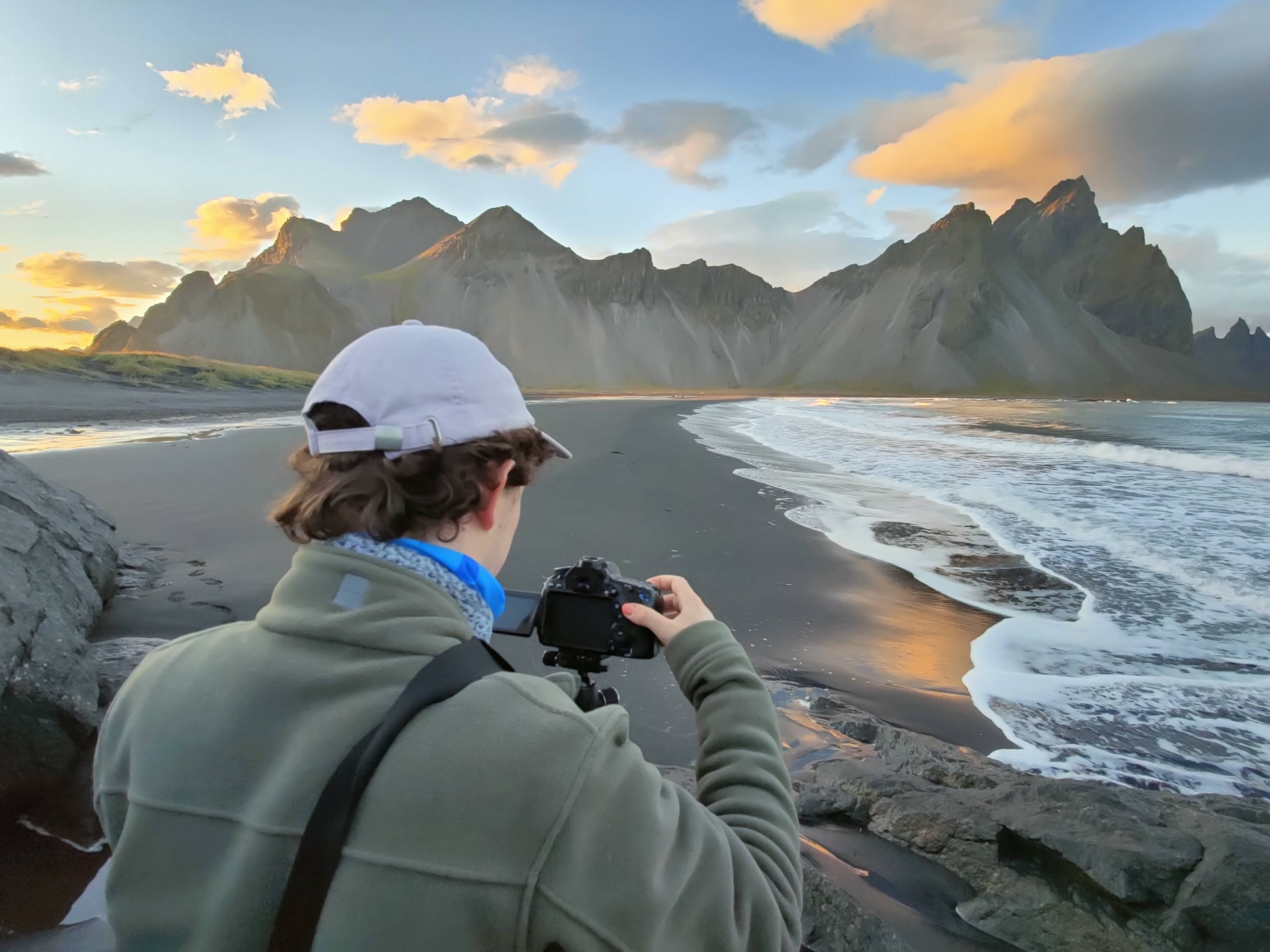 Me photographing a mountain range next to the sea